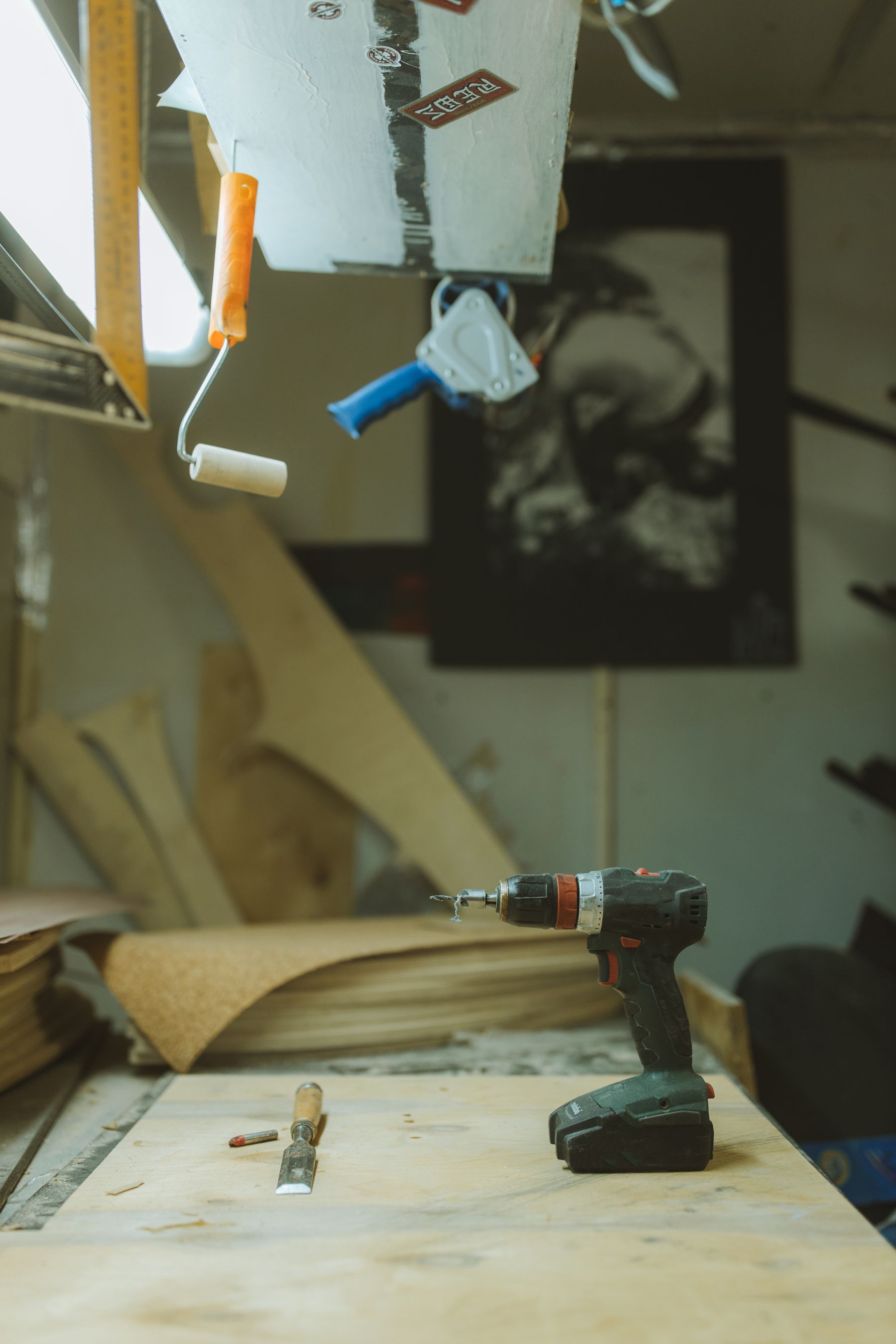 Cordless drill and hand tools arranged on a timber workbench